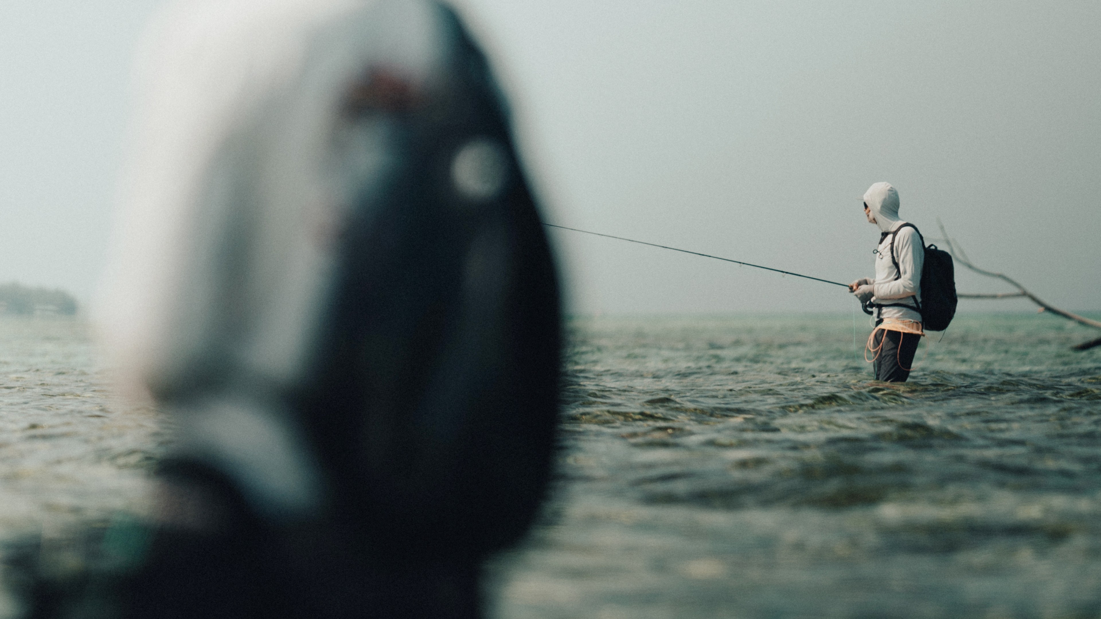 Two anglers wading shallow flats looking for permit and bonefish