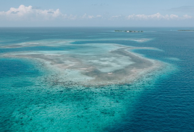 Aerial view over the flats outside Placencia, Belize. Showing both deep blue water and shallow pancake flats
